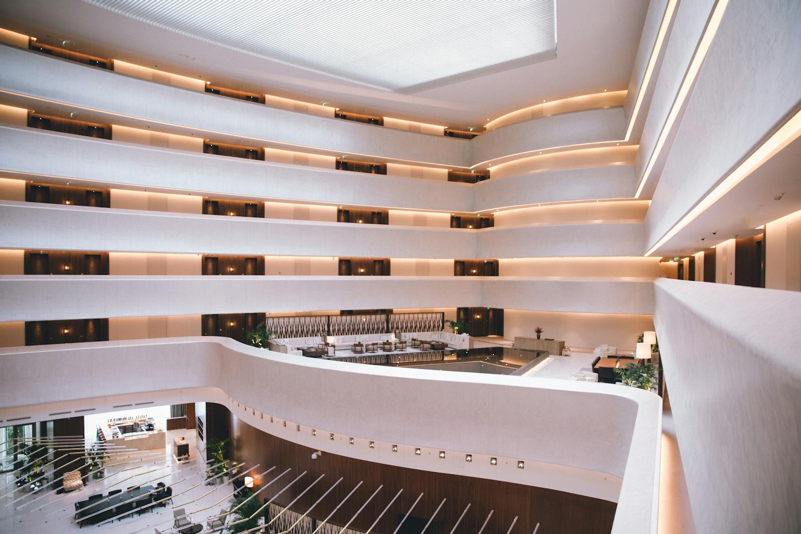 Moderner Hotel-Atrium mit mehreren Etagen und warmem Ambientelicht, professionell fotografiert.